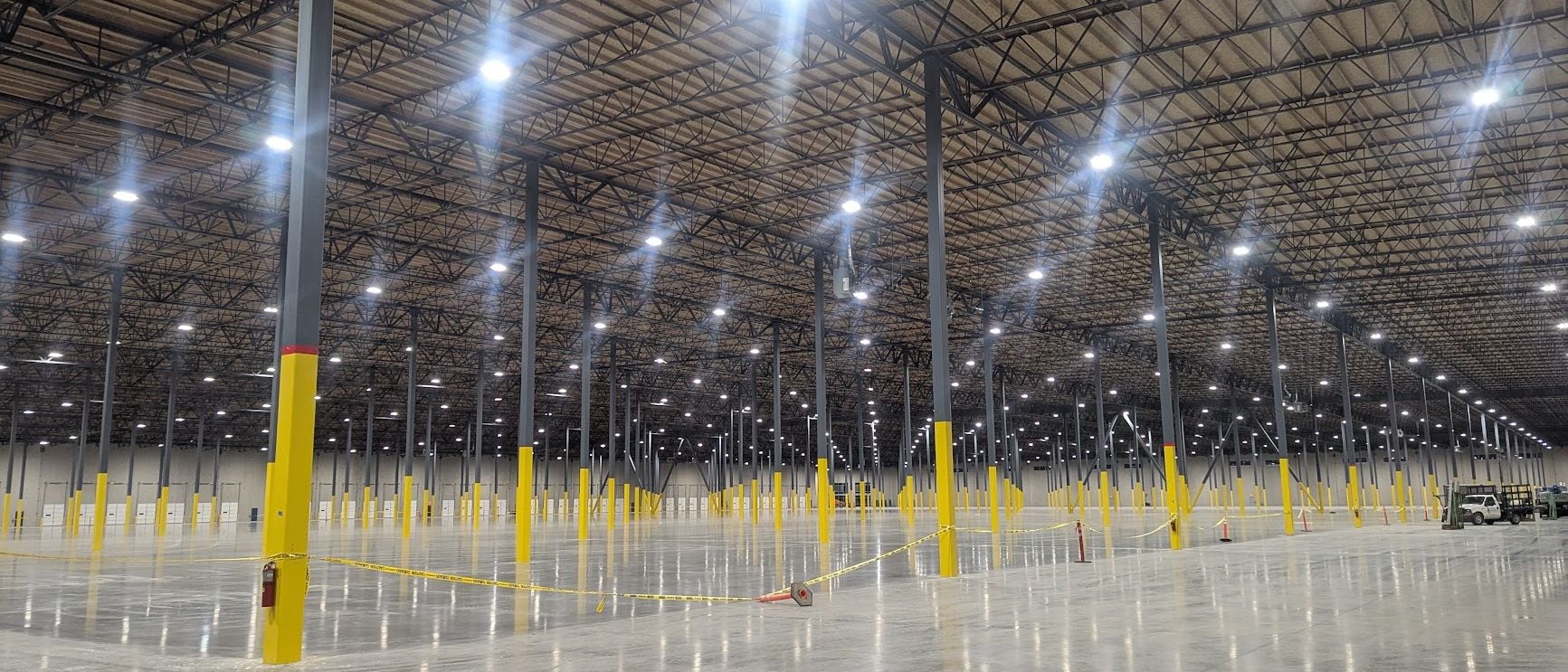 Warehouse interior lit by rows of newly installed high-bay LED fixtures