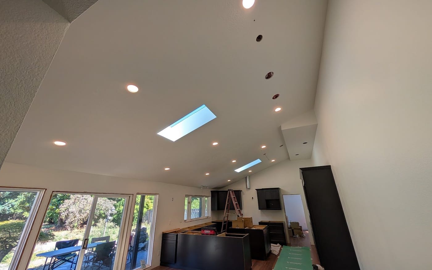 Recessed can lights being installed in a vaulted ceiling