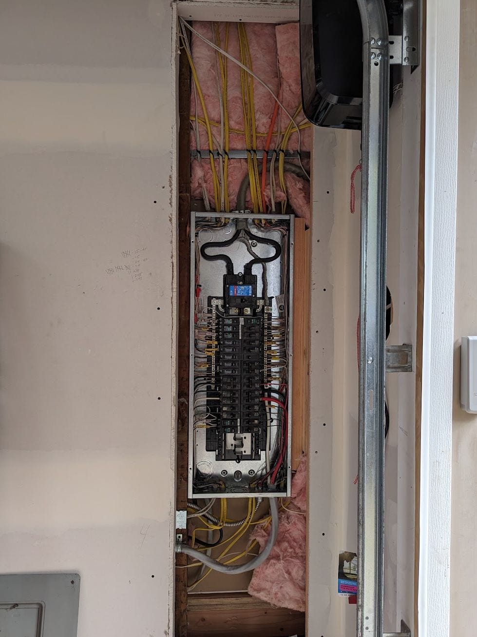 Electrical panel opened inside a wall cavity during troubleshooting