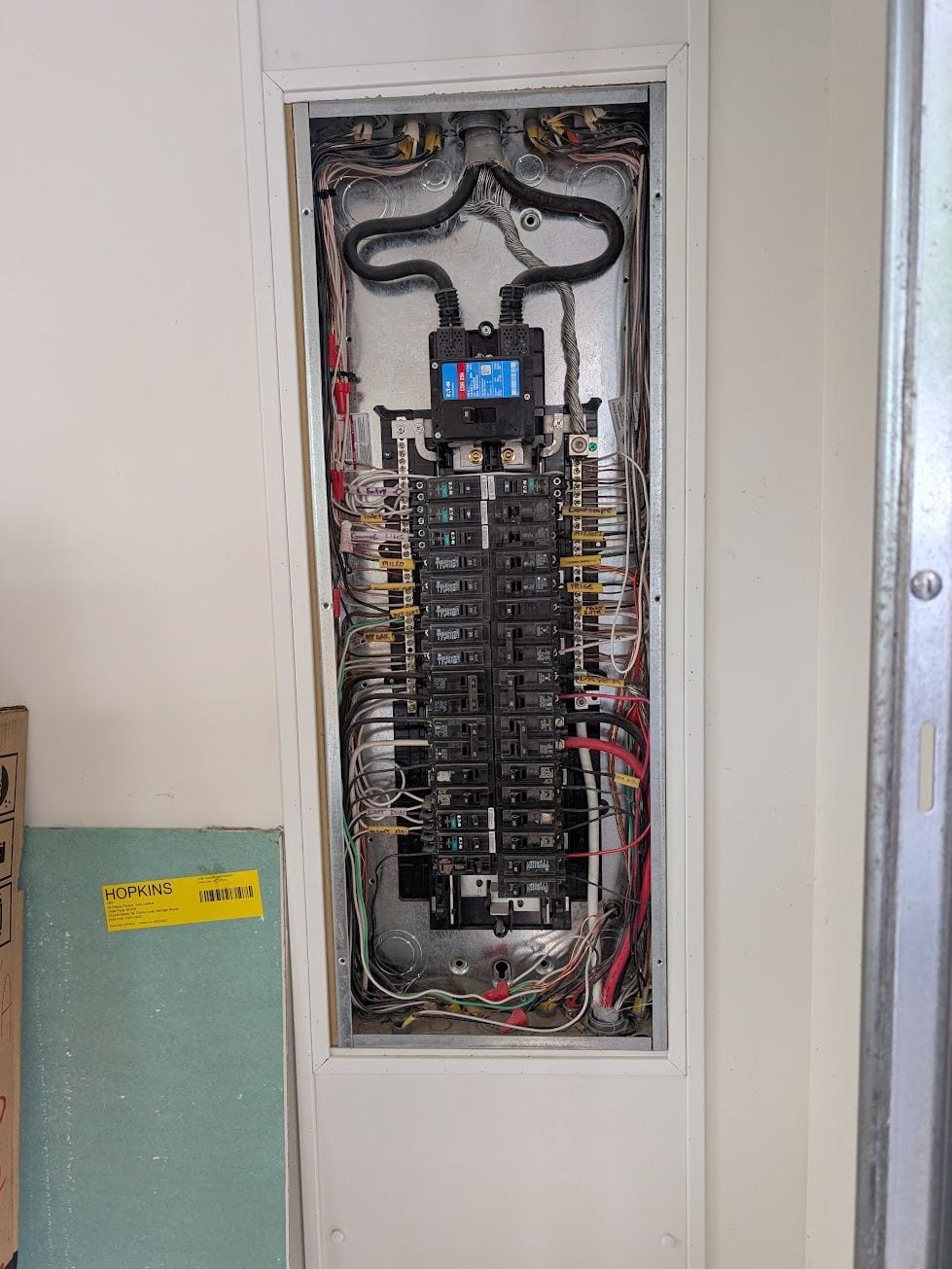 Existing electrical panel opened for inspection showing labeled breakers