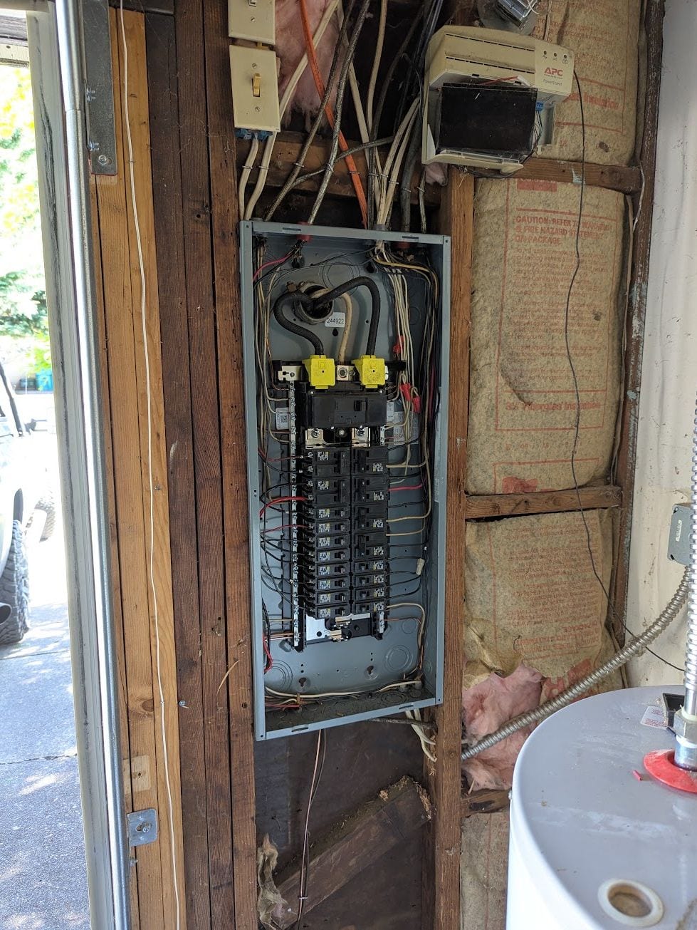 Residential service panel opened in a garage wall